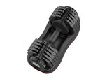Close-up of adjustable weight dial on black and orange dumbbell for strength exercises