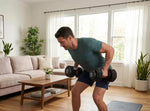 Man exercising with 50lbs adjustable dumbbells in a living room.