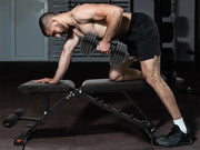 Man lifting weights on a bench in a gym setting