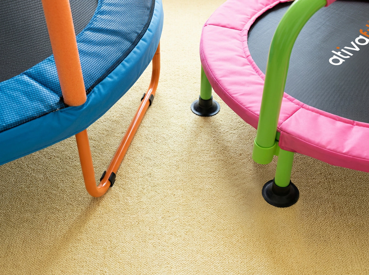 Two colorful trampolines on a carpeted floor, one with 'ativida' branding.