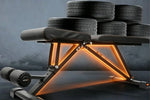Gym bench with tire weights on a dark background