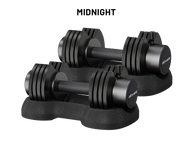 Two black adjustable dumbbells with weight plates on a matching black stand, shown on a white background with the text 'MIDNIGHT' above them. The brand name 'olivakt' is visible on the dumbbell ends.